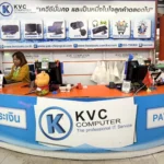 ภาพถ่ายภายในร้าน เควีซี คอมพิวเตอร์ เชียงราย แสดงเคาน์เตอร์ชำระเงิน มีป้ายบอกเวลาเปิด-ปิด 09:00-18:00 น. ข้อมูลติดต่อ เว็บไซต์ https://staging.store.kvc.computer/ เบอร์โทร 053 - 756 309 และสินค้าที่ขาย เช่น คอมพิวเตอร์, ปริ้นเตอร์, กล้องวงจรปิด